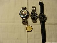 Four timepieces displayed: three wrist watches and one separate watch face. Watches include Betone, Tommy Hilfiger, and Roots brands.
