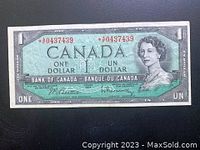 Front view of the 1954 Canadian one dollar replacement bill showing Queen Elizabeth II, serial numbers with asterisks, and Bank of Canada text.