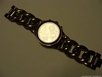 Full view of gold tone Michael Kors chronograph watch with linked band showing the entire item.