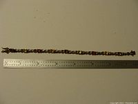 Full view of the bracelet with a ruler for size reference, showing the length and overall design.