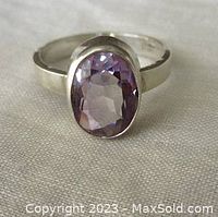Front and side view showing faceted oval light amethyst set in smooth sterling silver ring band, size approx. 7