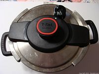 Top view of pressure cooker lid showing T-Fal Clipso branding and black handle with pressure knob