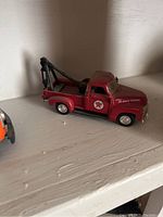 Red Texaco tow truck with Texaco logos and tow hook, visible from side view.
