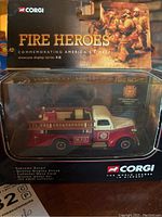 Photo showing Corgi Fire Heroes die cast fire truck in original packaging, commemorating America's Finest with detailed firefighter figures on box