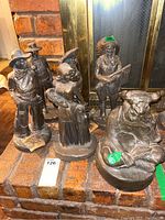 Full view of the six statues set on brick hearth near fireplace, showing variations in characters and postures