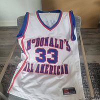 Front view of the white McDonald's All American basketball jersey with number 33 and 'McDonald's All American' text in blue and red, showing mesh material and Jordan brand patch.