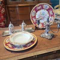Full view of all items including plates, candelabra, sugar and creamer set on silver tray.