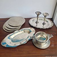 Photo showing 3 trays stacked on the left, an oval engraved tray in front and the bowl/underplate and 2 Birks candlesticks on the right.
