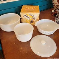 Image showing two white milk glass bowls, one large and one smaller, vintage Pyrex bowl with floral pattern alongside its broken lid, and boxed Italian Atlas pasta maker