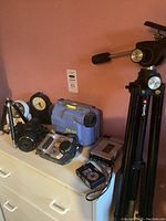 Fujifilm FinePix S6000fd digital camera next to clocks, Sony cassette recorder, Nikon Coolpix camera, tripod