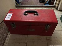 Closed red Craftsman metal toolbox with handle, slight wear visible on surface