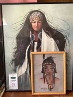 Photo showing both framed paintings together: a large portrait of Indigenous woman by Garcia and a smaller framed painting of a Native American figure by Chris Toffersey