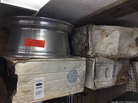 Four aluminium rims stacked on top of boxes showing storage condition and size tags