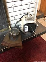 Helmet and separate canvas skirt laid on fireplace hearth