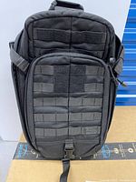 Front view of the black 5.11 tactical carry bag showing multiple zippered compartments, MOLLE webbing, and Velcro patches.