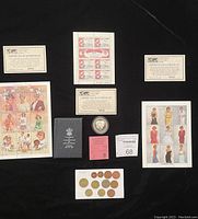 Overview photo showing all items flat on black surface including coin, stamps, certificates, booklet, and coins.