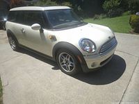 Front three-quarter view of cream white Mini Cooper Clubman parked in driveway