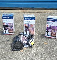 Three boxed Americana branded patriotic projection outdoor lights positioned upright with one projector unit placed in front showing the light lens and attached cord.