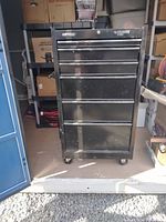 Front view of black rolling tool box showing 6 drawers and caster wheels