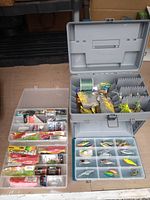 Open tackle box showing organized compartments full of various fishing lures and accessories