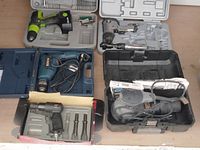 Photo showing 6 tools with their cases: cordless drill, Bosch electric drill, air impact wrench, air hammer with chisels, angle grinder, and drill bits case