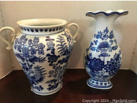 Photo showing two blue and white willow pattern ceramic vases, one with double handles and one with a fluted rim.