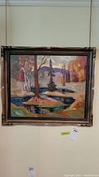 Full view of framed oil painting showing autumn landscape with trees and stream