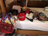 Photo showing all accessories including purses, hats, scarves, caps, and hosiery on a bed