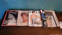 Five vintage magazines featuring covers with Queen Elizabeth II, Princess Diana and other royal family members.