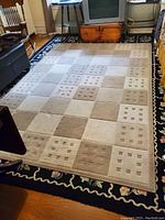 View of the tawny and beige checkerboard patterned rug on floor with textured small square dot designs visible