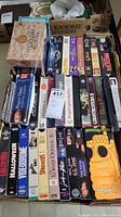 Top view of the box showing a variety of VHS movies arranged in rows inside a reused organic blueberries cardboard box.