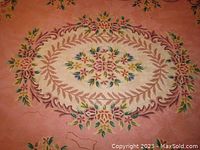 Close-up of the central area of the rug showing the floral medallion and some visible wear marks.