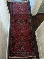 Full view of the 101 x 33 inch Iranian oriental rug runner showing detailed floral and geometric patterns with red as dominant color.