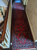 Full length view of the long oriental rug runner placed along a hallway showing its overall appearance and color scheme.