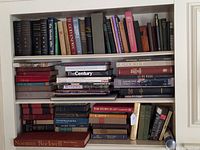 Wide view of three shelves filled with assorted hardcover books