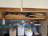 Stack of cutting boards on shelf, includes wood and synthetic materials