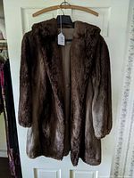 Front view of the full vintage brown sheared beaver fur coat hanging showing mid-length and plush fur texture.
