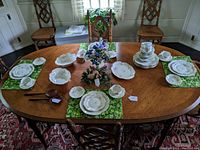 Full view of the dining table displaying the various pieces of the dinner service set arranged for eight, including serving bowls and platters.