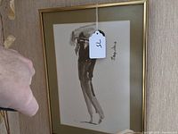 Framed watercolor artwork showing the full figure of a jazz upright bass player in monochromatic shades, with a hanging tag marked '15'.