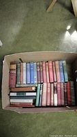 Full box packed with circa 30 old hardcover books with colorful cloth bindings in various conditions.