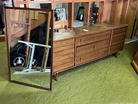 Full view of dresser and mirror on green carpet