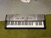 Top view of Casio LK-230 keyboard showing keys, function buttons, and digital display.