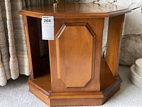Octagonal solid wood maple side table showing one panel with decorative recessed panel and finish, visible wear.