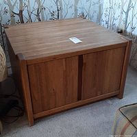 Front angled view showing solid oak end table with vertical panels on sides and wood grain top surface with light wear.