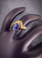 Front view showing oval sapphire bezel set and diamond accents
