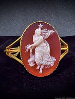 Front view of oval shell cameo carving set in scalloped 14K gold bezel