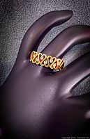 Ring displayed on a black mannequin hand at slight angle showing heart motif and diamond settings