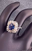 Front view of ring showing central sapphire and diamond halo