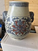 Front view showing entire vase with floral patterns and elephant head handles