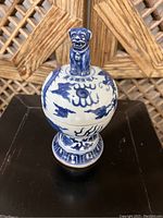 Front view of the blue and white porcelain incense burner showing Foo Dog figurine on lid and dragon decoration on body.